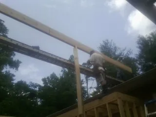 Carpenter setting a ridge beam over a new addition frame — Ice Dam Removal by Roofing Brothers in La Junta