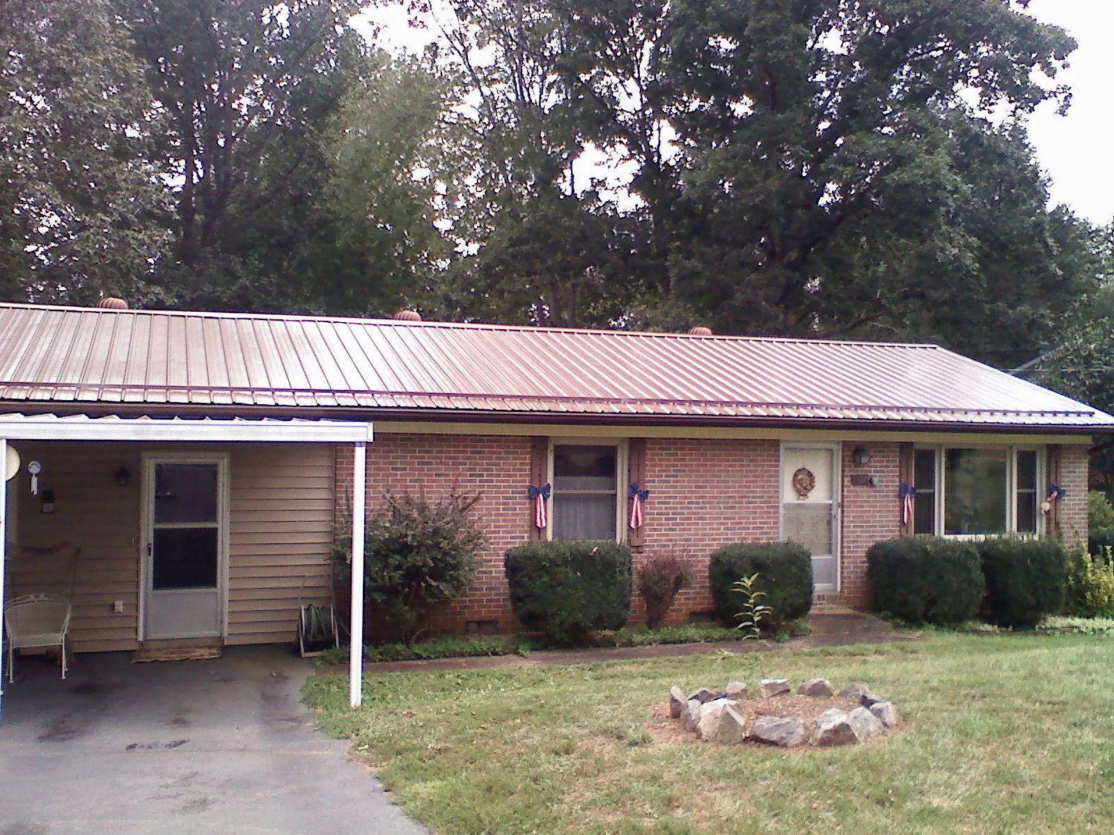 Bronze metal roof and carport on a brick ranch home — Roof Repair work by our crew in La Junta